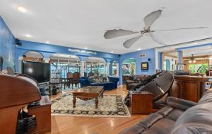 ein Wohnzimmer mit blauen Wänden und einem Deckenventilator in der Unterkunft Luxury Five-Bedroom Riverfront Villa with Private Pool in Daytona Beach