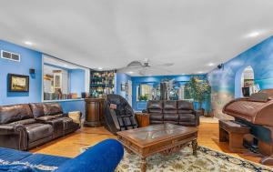 ein Wohnzimmer mit einer Couch und einem Klavier in der Unterkunft Luxury Five-Bedroom Riverfront Villa with Private Pool in Daytona Beach