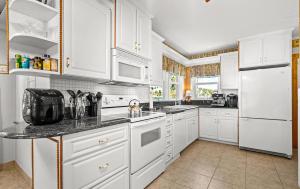 eine Küche mit weißen Schränken und weißen Geräten in der Unterkunft Luxury Five-Bedroom Riverfront Villa with Private Pool in Daytona Beach + 55 Fotos