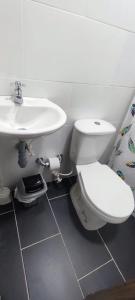 ein Badezimmer mit einer weißen Toilette und einem Waschbecken in der Unterkunft Amplio Apartamento Renovado 150m2 para Familias, Grupos o Delegaciones Deportivas - Estadio Atanasio Girardot in Medellín