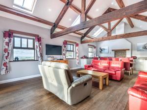 ein Wohnzimmer mit roten Möbeln und Holzdecken in der Unterkunft Stack View Cottage in Holyhead