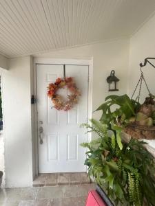 uma porta branca com uma coroa de flores em Miramar's Studio em Miramar