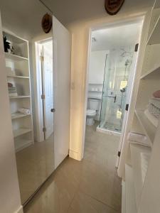 um banheiro com chuveiro, vaso sanitário e espelho em Miramar's Studio em Miramar