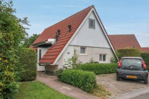 une voiture garée devant une maison avec un toit rouge dans l'établissement Merle 6 pers Modern holiday home with private fenced garden, à Anjum