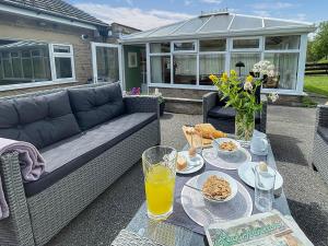 a patio with a couch and a table with food at Keepsake View in Two Dales