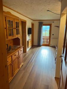 a large kitchen with wooden floors and a large window at Ferienwohnung Lahnerhof in Arriach