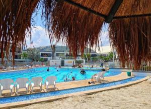 a swimming pool with chairs and people in it at Ciudadela Santafe in Santa Fe de Antioquia +24 photos