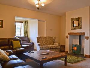 a living room with couches and a table and a fireplace at Celyn in Montgomery