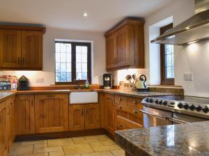 a large kitchen with wooden cabinets and a sink at Celyn in Montgomery +18 photos