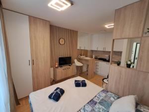 a bedroom with a bed and a kitchen with a clock at Apartman Pahuljica in Pale