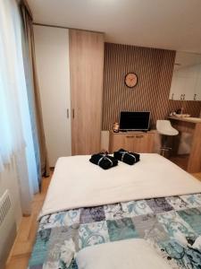 a bedroom with a bed with two bags on it at Apartman Pahuljica in Pale +4 photos