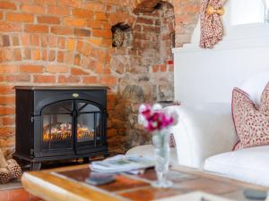 een woonkamer met een open haard en een witte bank bij Elsie's Cottage in Pontesbury