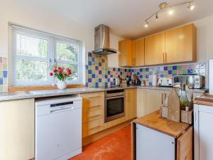 een keuken met houten kasten en een aanrechtblad bij Elsie's Cottage in Pontesbury +25 foto's