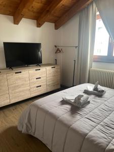 a bedroom with a large bed and a television at VILLA LIDO - Lake Como in Colico