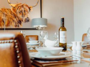 a bottle of wine sitting on a table with glasses at St David's Lodge - Uk6738 in Lydstep