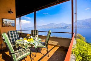 a table and chairs on a balcony with a view of the water at Residenz Roccolo in Ghiffa