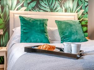 a tray of food on a bed with a plate of food at Vitamin Sea Residency in Herne Bay +32 photos