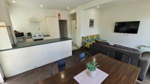 a living room with a kitchen and a table and a couch at U Studios Paraparaumu, SureStay Collection by BW in Paraparaumu Beach