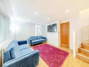 a living room with a blue couch and a red rug at Violet Cottage - Uk45968 in Yarm
