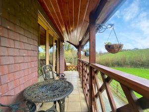 een veranda van een huis met een tafel en een schommel bij Maple - Uk46284 in Camerton +24 foto's