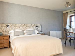 a bedroom with a large bed and a chair at Midcraigs in Kilchenzie