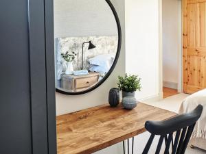a mirror over a wooden table in a bedroom at Midcraigs in Kilchenzie
