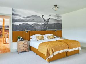 a bedroom with a bed with a deer mural on the wall at Midcraigs in Kilchenzie +5 photos