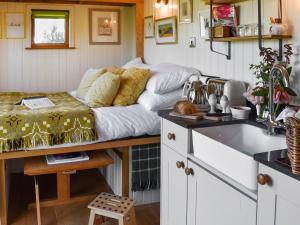 a couch sitting on a table in a kitchen at Shepherds Hut - Ukc6774 in Llanallgo
