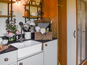 a kitchen with a sink and a basket on the counter at Shepherds Hut - Ukc6774 in Llanallgo