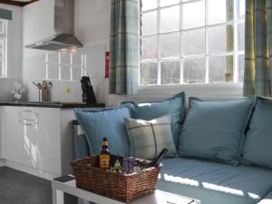 a living room with a blue couch with a basket on a table at Field House Lodge in Borrowdale Valley