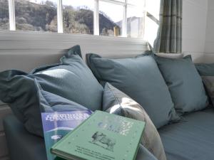 a book sitting on top of a couch with pillows at Field House Lodge in Borrowdale Valley
