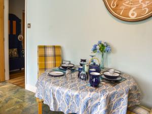 a table with plates and vases on it at Grooms Cottage in Choppington