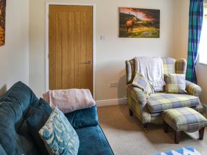 a living room with a couch and a chair at Grooms Cottage in Choppington