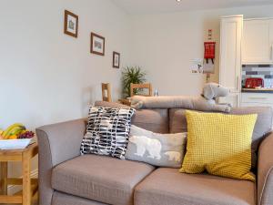 een woonkamer met een bank met kussens erop bij Croft Cottage 1 - Uk10587 in Stillington