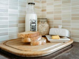 a cutting board with bread and a bottle of milk at Drumwherry By The Sea in Monreith