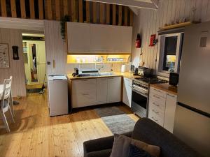 a kitchen with white cabinets and a stove top oven at Cheerful forest cabin Fireplace and Hot tub in Akranes +33 photos