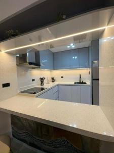 een grote keuken met witte aanrechtbladen en blauwe kasten bij MaryHospedaje in Valencia +3 foto's