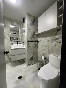 een badkamer met een wit toilet en een wastafel bij MaryHospedaje in Valencia