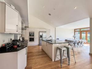 a kitchen with white cabinets and a dining room at Springfields in North Wootton
