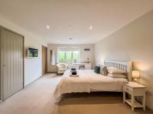 a bedroom with a bed and a chair in a room at Springfields in North Wootton