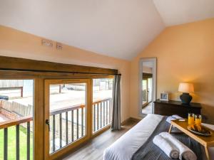 Un dormitorio con una cama y un balcón. en Orchard Barn - Uk47458, en Chetton