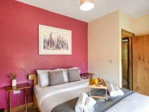 Un dormitorio con una cama y una pared roja. en Orchard Barn - Uk47458, en Chetton