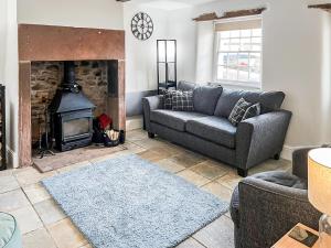 a living room with a couch and a fireplace at Dunmallet in Pooley Bridge