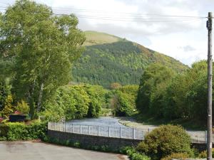 a river with a fence next to a mountain at Laal Yan in Keswick +2 photos