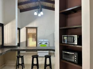 ハコにあるMacaw Paradiseの部屋にカウンターとスツールがあるキッチン