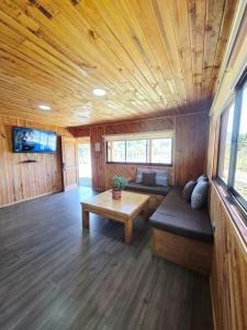 una sala de estar con un sofá y una mesa en Cabañas Don Agustín Pucón, en Pucón