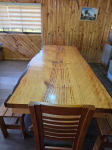 una gran mesa de madera en una habitación con silla en Cabañas Don Agustín Pucón, en Pucón