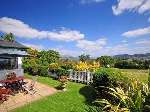 un jardin avec une table, des chaises et une clôture dans l'établissement Fron - Cottage, à Mynfford 19 autres photos