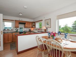 une cuisine avec une table et des chaises en bois ainsi qu'une cuisine avec un comptoir dans l'établissement Fron - Cottage, à Mynfford