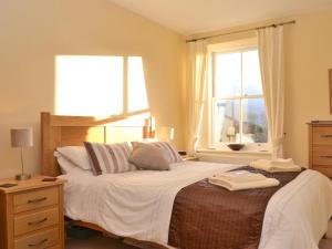 a bedroom with a large bed with a window at Bishop View in Braithwaite